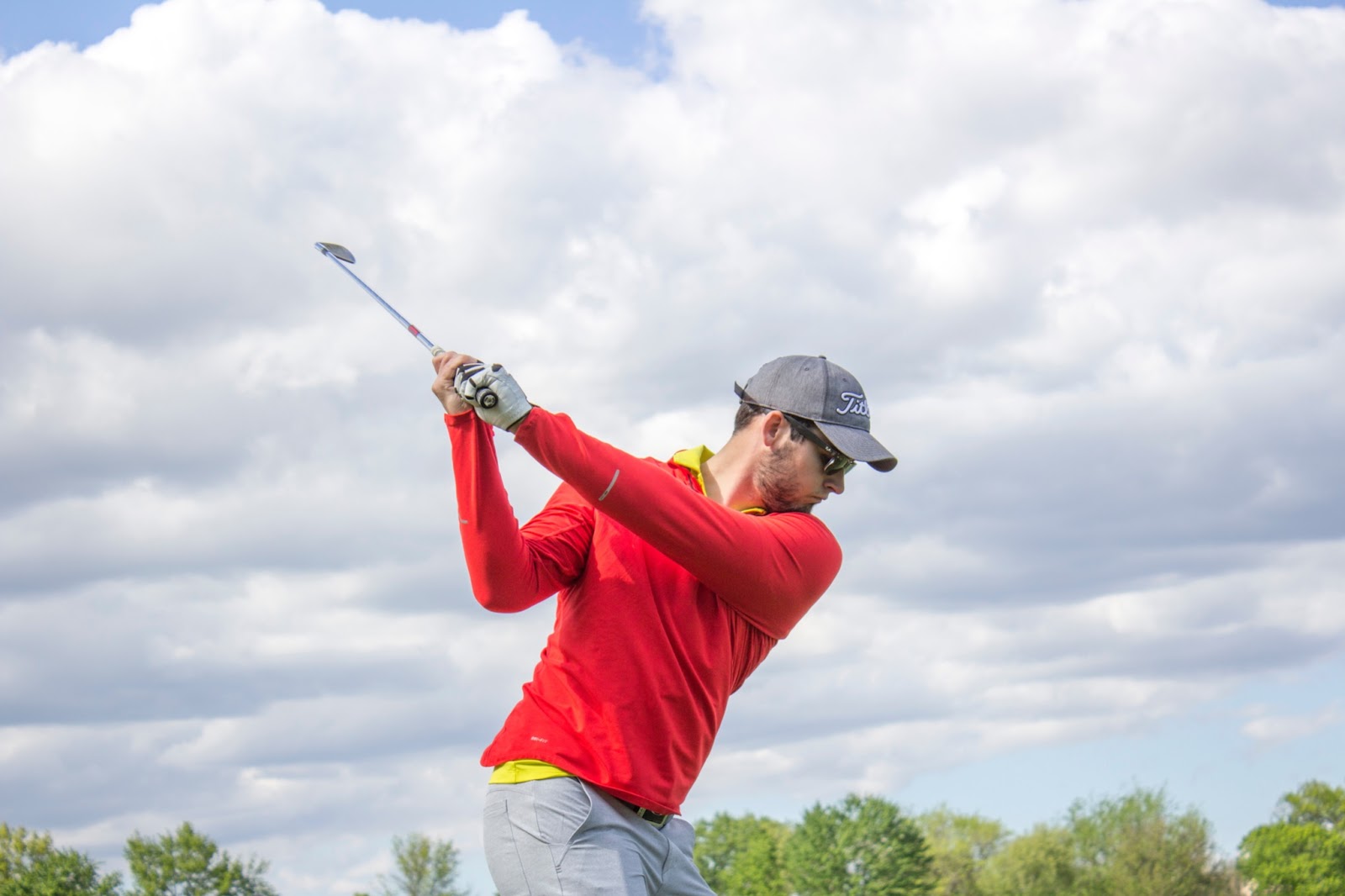 Golfer with arms connected throughout the golf swing in the backswing