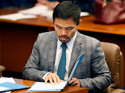 A file photo of Philippine Senator and boxing champion Manny Pacquiao reading his briefing materials as he prepares for the Senate session in Pasay city, Metro Manila. 