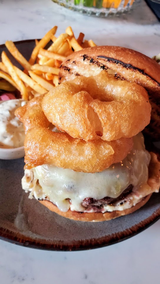 Normandie PDX Burger on Briochea with famous 5 Hour Onions, Alpine Cheeses, and Mustard Aioli