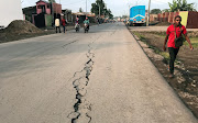 A pedestrian walks near a crack on the road caused by earth tremors as aftershocks following the eruption of Mount Nyiragongo volcano near Goma, in the Democratic Republic of Congo May 26, 2021. 