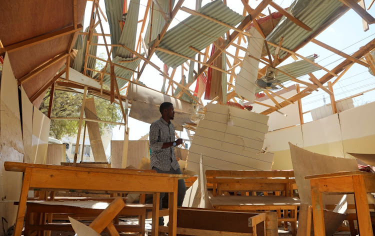 Anwar Mohamud Abdulahi, a student, stands among debris of a classroom after a car exploded in a suicide attack near Mucassar primary and secondary school in Hodan district of Mogadishu, Somalia November 25, 2021