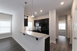 Kitchen with black appliances, dark cabinets, and wood-inspired flooring