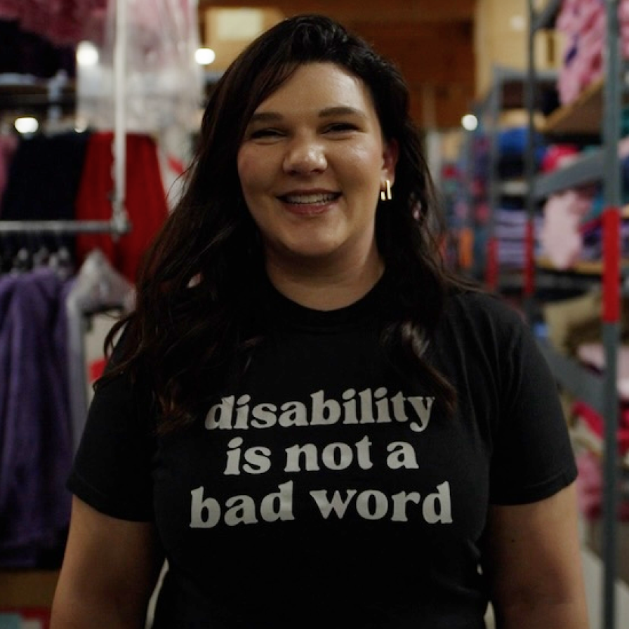 A person wearing a T-shirt that reads 'disability is not a bad word'