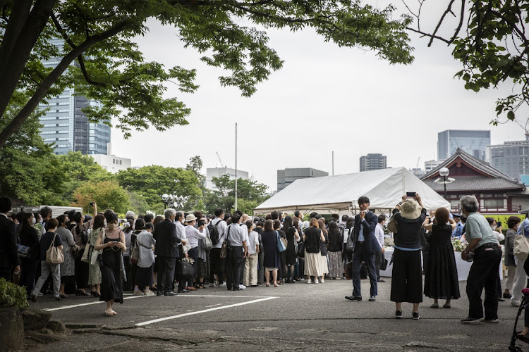 People line up for flower offering at Zojoji temple on the day of the funeral for former Japanese Prime Minister Shinzo Abe on July 12 2022 in Tokyo, Japan. Picture: GETTY IMAGES/YUICHI YAMAZAKI