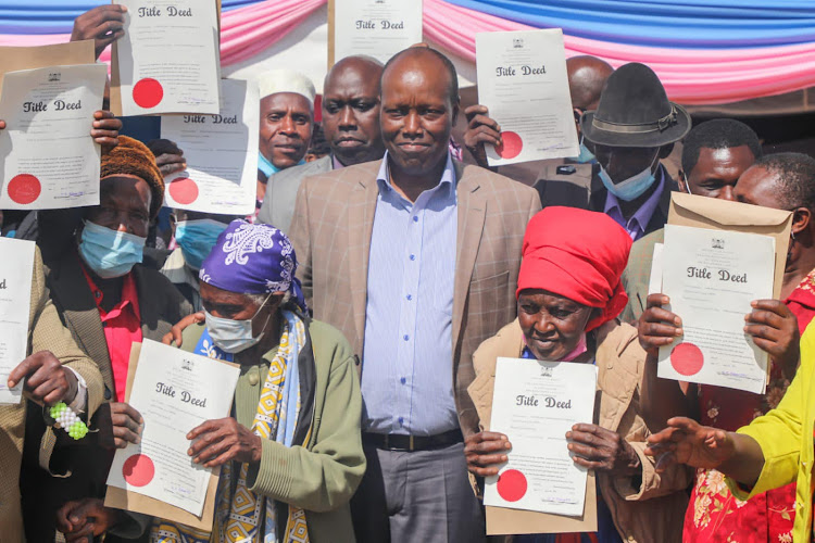 Nakuru Governor, Lee Kinyanjui poses for a photo with a some of the beneficiary of the County Government Titling program at Giwa Settlement Scheme in Ronga on November 16, 2021.