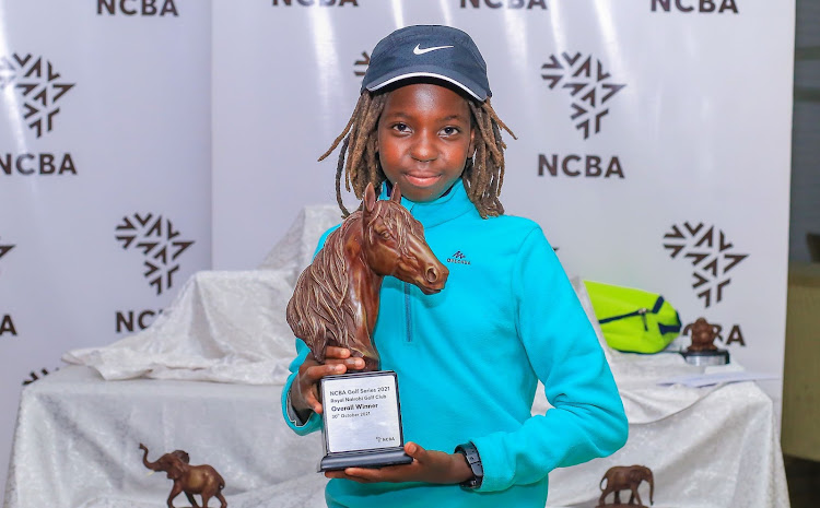 Cherono Kipkorir poses with her overall winners trophy following her victory at Royal Nairobi Golf club leg of the 2021 NCBA golf series.