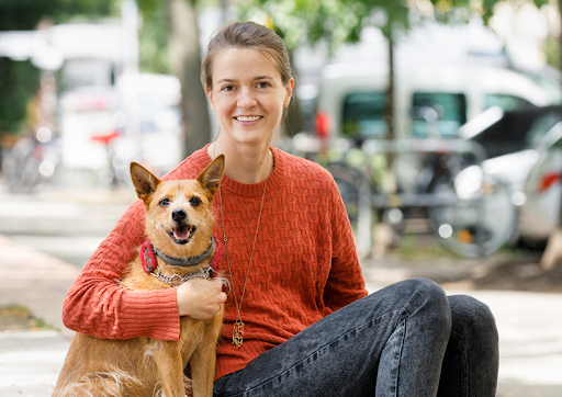 Dogo Founder, Rasa, and her dog, Ūdra, smile for the camera.