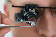 Person Looking At Diamond With Magnifying Loupe.