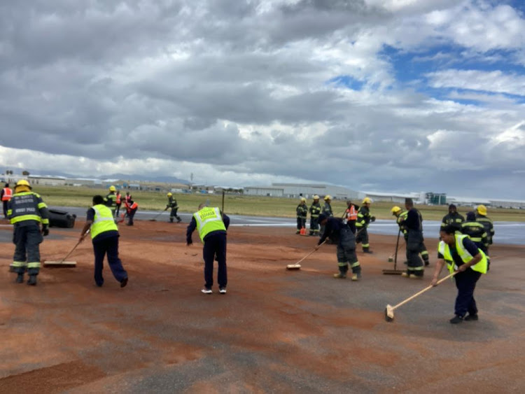 Acsa staff clear a hydraulic fuel spill on the main runway at Cape Town International Airport.