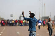 A community leader of Majakaneng tries to calm the residents during a blockade of the road leading to Mooinooi during a protest over a man who was allegedly killed by a farmer.