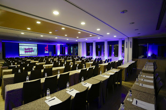 una sala de conferencias llena de mesas y sillas