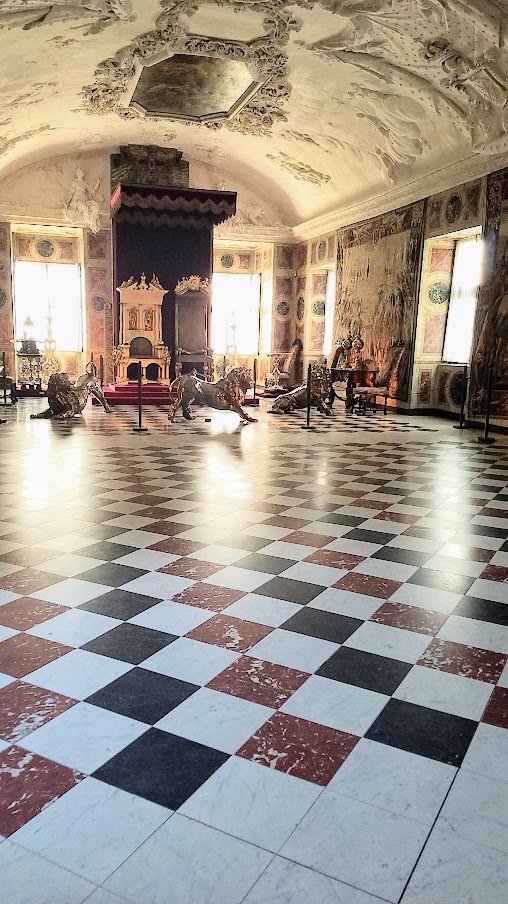 Visiting Rosenborg Castle in Copenhagen. On the third floor and is where you'll find the impressive Throne Room, also known as the Long Hall or Knights’ Hall. It was intended as a ballroom, and here you will find the coronation thrones for the king and queen and three life-size silver lions standing guard. On the other side of the room is displayed the throne for audience.