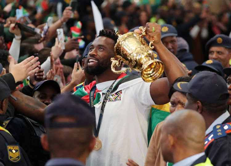 Springbok captain Siya Kolisi proudly holds aloft the Webb Ellis Cup as the team arrives at OR Tambo International Airport in Johannesburg on Tuesday after winning the Rugby World Cup final against New Zealand in Paris.