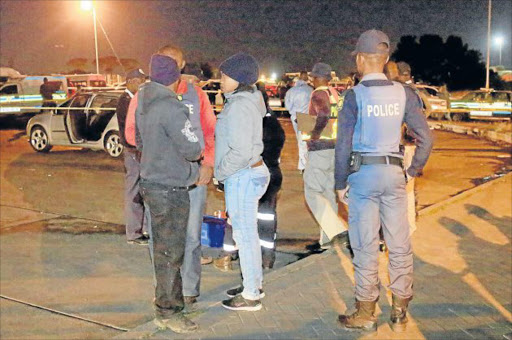 SENSELESS: Police officers at the scene where a Mdantsane taxi owner was gunned down at Highway Taxi Rank yesterday evening Picture: SINO MAJANGAZA