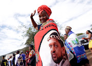 A woman wears a cloth bearing the face of King MisuZulu.