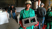 Siboniso Gumede poses with one of the bricks produced using recyclable material at the Midmar depot. 