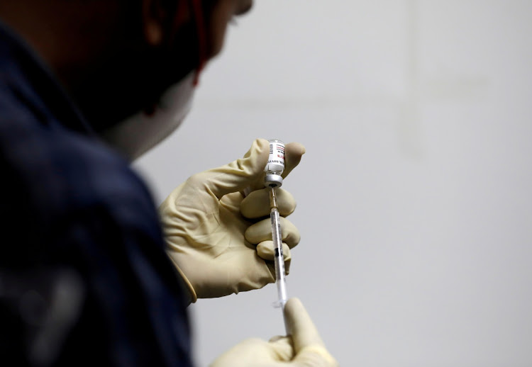 A medic fills a syringe with COVAXIN, an Indian government-backed experimental Covid-19 vaccine, before administering it to a health worker during its trials, at the Gujarat Medical Education and Research Society in Ahmedabad, India, November 26, 2020.