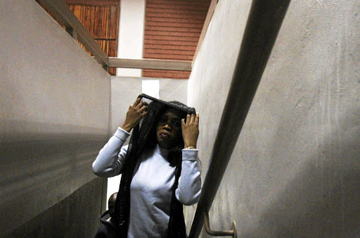 Malibyane Maoeng tries to cover her face after appearing for fraud in the Benoni magistrate's court.