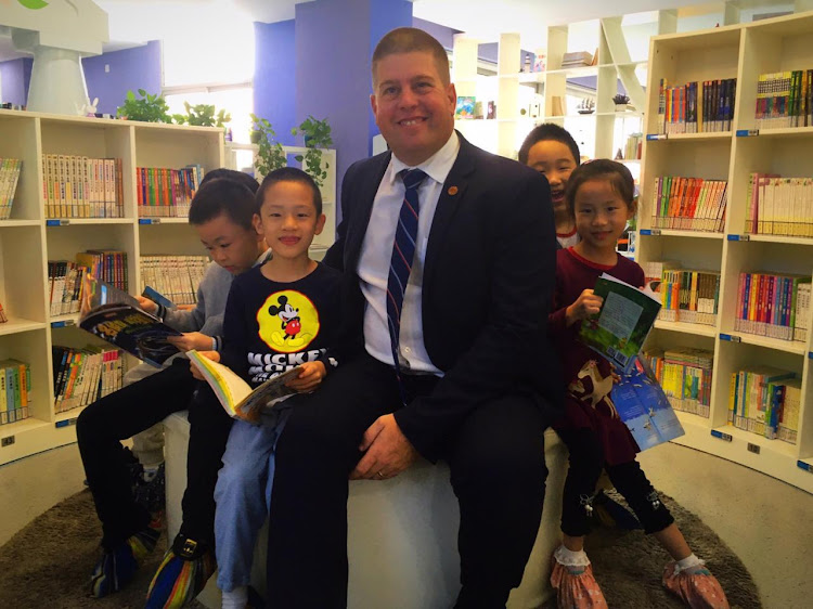 Grey Junior School deputy headmaster Grant Douglas with a group of pupils at a school in Shanghai during a trip by 25 SA principals to China