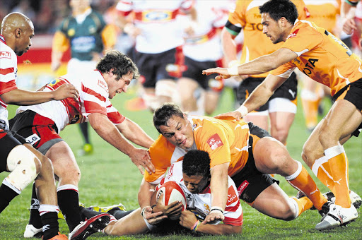 Coenie Oosthuizen tackles Elton Jantjies during the Absa Currie Cup match between Golden Lions and Free State Cheetahs at Ellis Park, Johannesburg on Saturday. The Lions top the Currie Cup log but it's too early say whether they are title contenders Picture: LEE WARREN/GALLO IMAGES