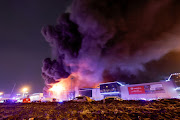 Smoke from fire rises above the burning Crocus City Hall concert venue following a shooting incident, outside Moscow, Russia, March 22, 2024.