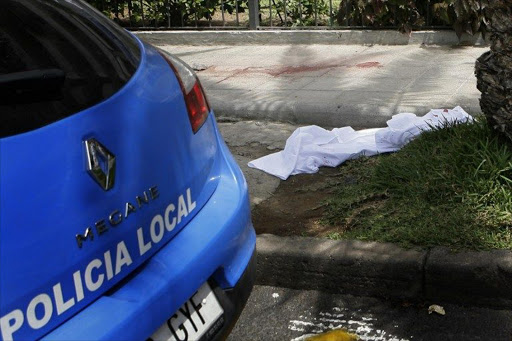 A white sheet covers the place where a man deposit the head of a British woman after decapitated her in a supermarket in Los Cristianos, on the Spanish resort island of Tenerife.