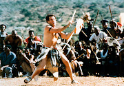 Johnny Clegg dances for a group of men. 