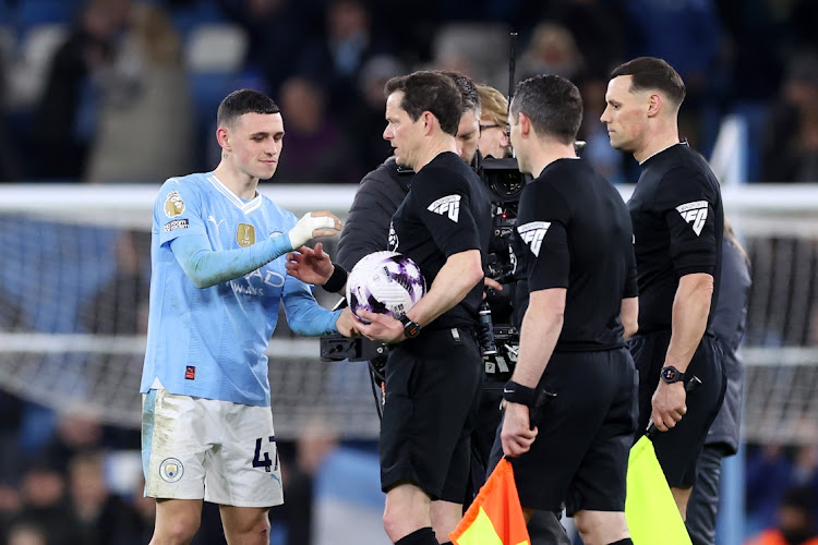 Phil Foden of Manchester City receives the match ball from referee Darren England after his hat-trick in the Premier League match against Aston Villa at Etihad Stadium in Manchester on Wednesday night.