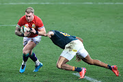 Stuart Hogg of the British & Irish Lions is tackled by Lukhanyo Am of the Springboks during the second Test at Cape Town Stadium on July 31 2021