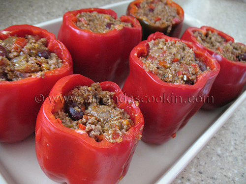 A close up photo of six unbaked chili and cornbread stuffed peppers.