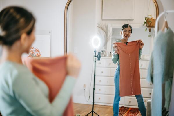 foto de uma mulher mostrando uma roupa no espelho