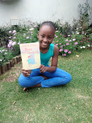 Young bibliophile Nosipho Nkosi poses with 'Bau and the Baobab'. 