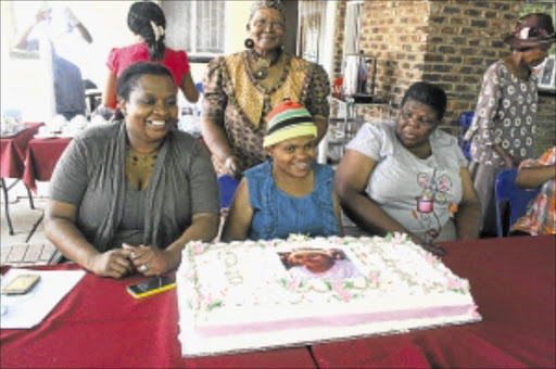 ALL SMILES: Mpho Mathibela, centre seated, looks happy after being thrown a surprise birthday party. PHOTO: SIBUSISO MSIBI