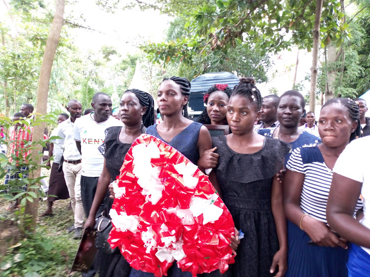 Eric Oloo's widow Lucy Oloo leads a procession to the gravesite at his Ugunja home on Saturday