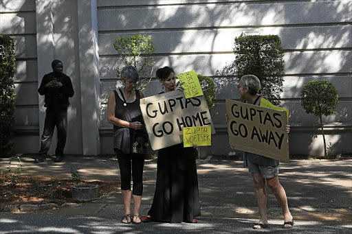 THREE'S THE CROWD: A small group of 'concerned citizens' picket outside the Gupta home in Saxonwold, Johannesburg. The police were called to the scene but left without acting