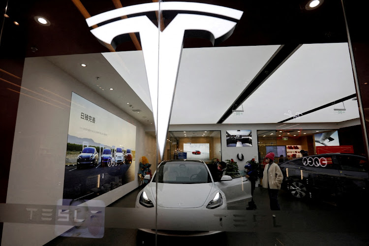 Visitors inspect a Tesla Model 3 car next to a Model Y displayed at the carmaker’s showroom in Beijing, China. Picture: REUTERS/FLORENCE LO