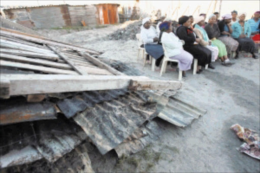 FAMILY TRAGEDY: Neighbours and the family of Bulelwa Matewu, whose four children died in a shack fire in Khayelitsha on Monday. PHOTO: ELVIS KA NYELENZI