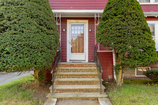House entrance with stairs and trees in this luxury property for sale in Medford ($995,000)