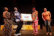 Minister of Sports, Arts and Culture Zizi Kodwa is flanked by Playhouse CEO, Linda Bukhosini and chairperson Khwezi Kunene as he honours Dr Madala Kunene with an award during his honorary concert at Playhouse in Durban.