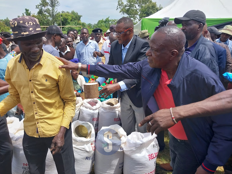 CS Eliud Owalo and Fred Outa during a relief food distribution in Gem Wagai on Friday.