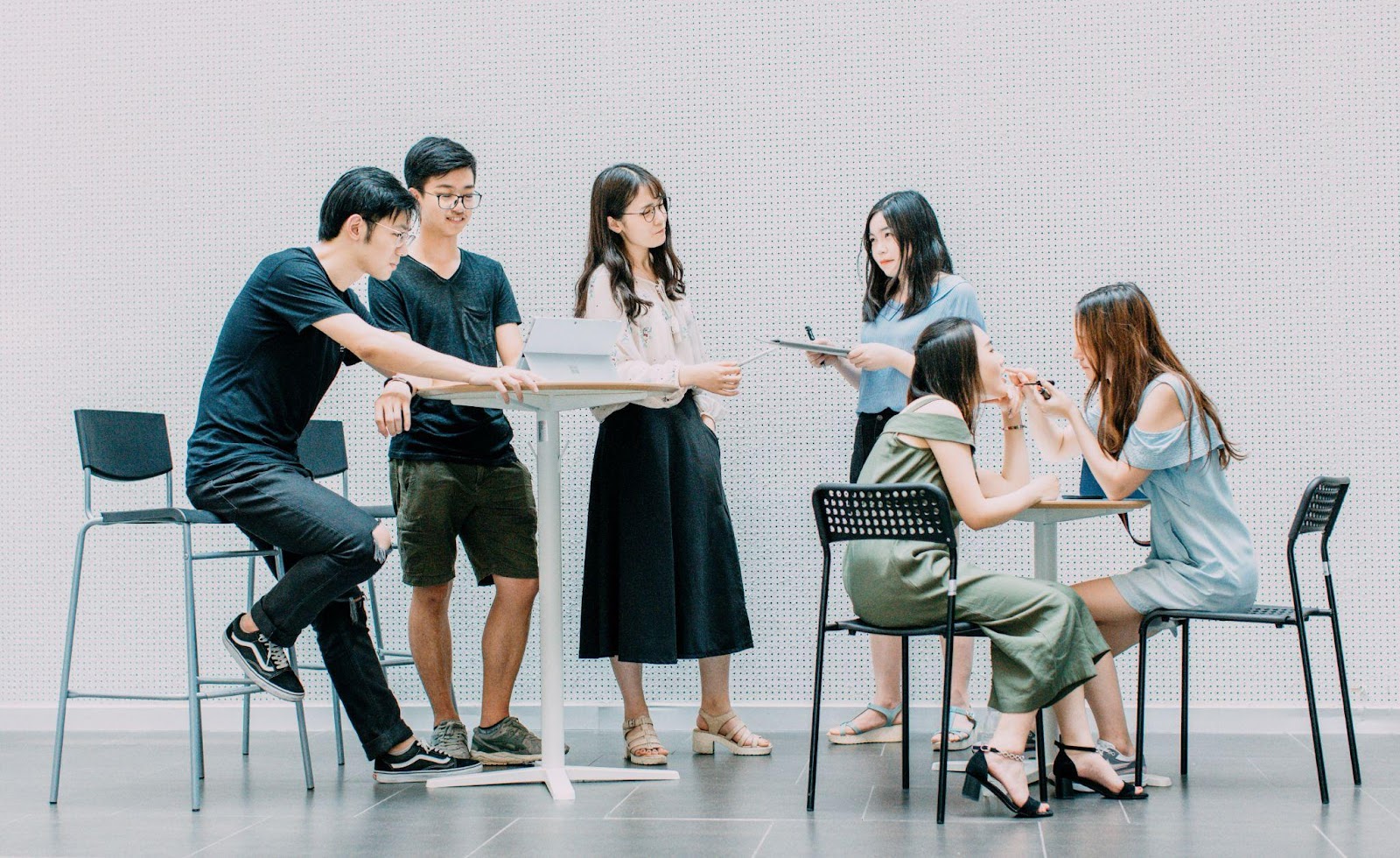 Group of People Working Together Some at a Table and Some at a Computer