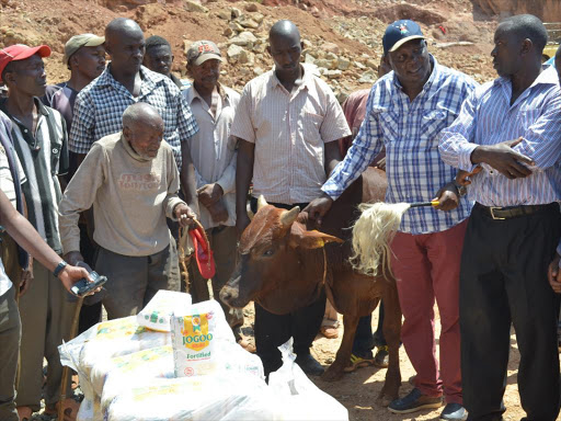 Ahadi Kenya Trust CEO Stanley Kamau donating a bull and four bales of maize floor to Kiamunyaga quarry workers, Saturday, December 23, 2017. /ALICE WAITHERA