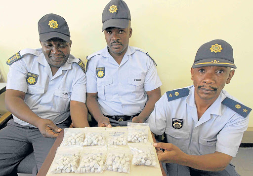 SUCCESS: Madeira Police Station visible police unit Warrant Officer Welile Ntangashe, left, Constable Nzolo Melane, centre, and commander Colonel Maphelo Ngame with the 369 mandrax tablets worth about R37000 they found in York Road in Mthatha on Saturday Picture: LULAMILE FENI