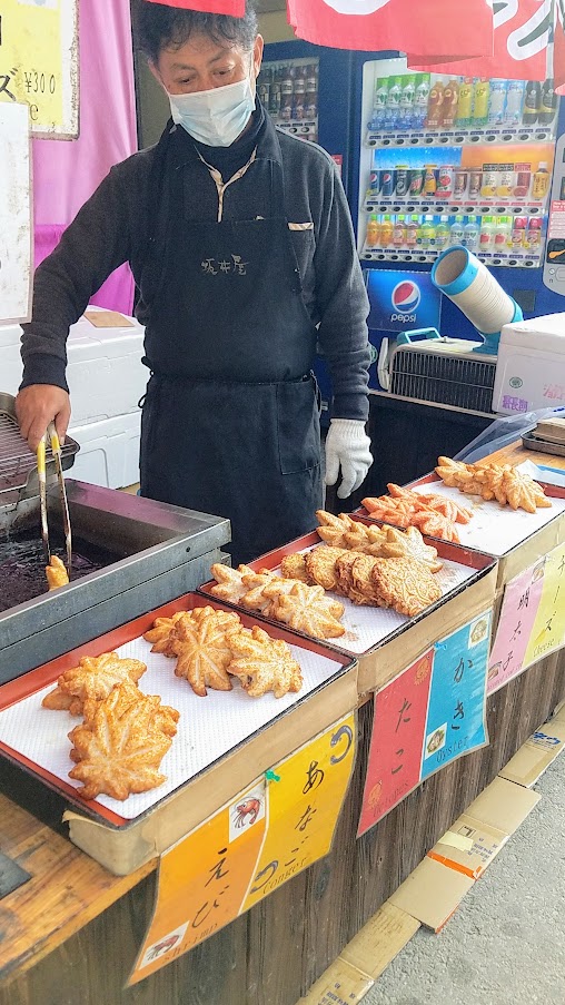 Hiroshima Day trip to Miyajima. One thing you will notice that is plentiful in Miyajima while you are killing time as the tide rises or falls is the food! There are many street stands with various treats such as seen here kamaboko, a bunch of steamed then grilled skewers of surimi, aka fishcakes made of pureed seafood. The types available at the stand I saw included oyster, octopus, seasoned cod roe, shrimp, eel, and cheese.