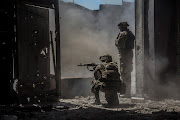 Ukrainian service members watch while a tank (not pictured) fires toward Russian troops in the industrial area of the city of Sievierodonetsk, as Russia's attack on Ukraine continues, Ukraine June 20, 2022. 