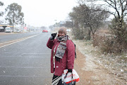 Salmina Lephoto reacts to the snow on her morning commute to work, 10 July 2023, in Liefde en Vrede, South of Johannesburg.  