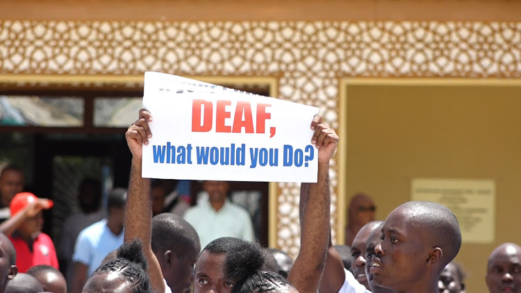 A deaf person displays a poster to share his concerns during the International deaf awareness week celebrations in Malindi, Kilifi County.