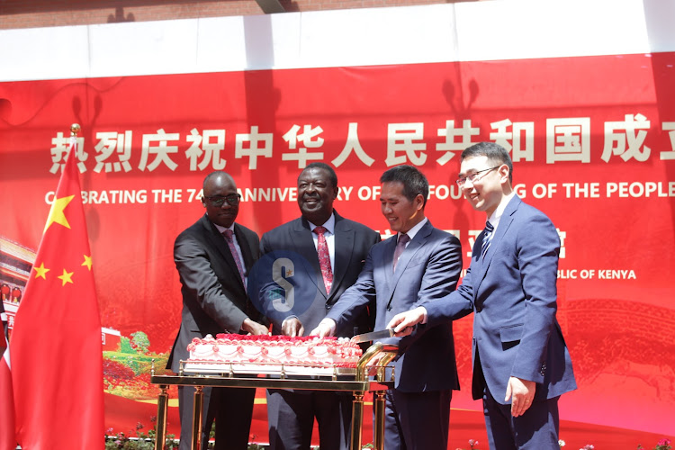 Prime Cabinet secretary Musalia Mudavadi, China's ambassador to Kenya Zhou Pingjian, PS Foreign affairs cut a cake to celebrate the 74th anniversary of the founding of the Peoples Republic of China at the embassy headquarters in Nairobi on September 27, 2023.