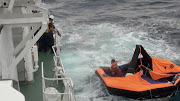 A Filipino crew member of Gulf Livestock 1, a cargo ship carrying livestock and dozens of crew that went missing after issuing a distress signal due to Typhoon Maysak, floating on a life raft, is rescued by Japan Coast Guard crew onboard the vessel Kaimon at the East China Sea, to the west of Amami Oshima island in southwestern Japan, on September 4 2020. 