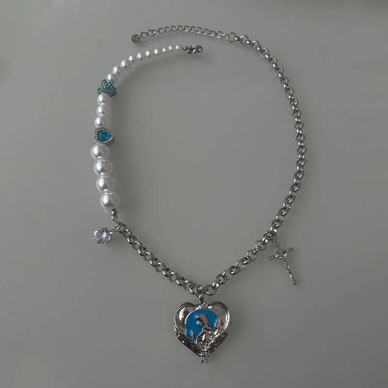 Plava biserna ogrlica sa šavom srca i krstom, romantičan nakit koji izražava ljubav, veru i eleganciju. Savršen poklon.